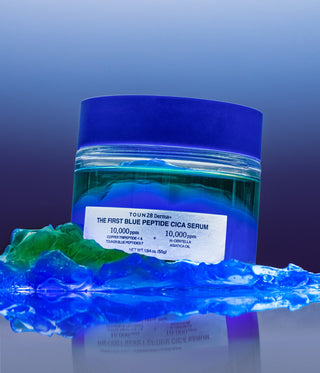1% Blue Peptide Cica Serum jar surrounded by blue water gel and green oil gel texture