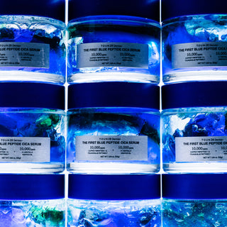 Stacked jars of 1% Blue Peptide Cica Serum showing dual-layer blue and green gel