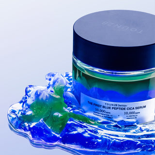 1% Blue Peptide Cica Serum jar resting in a pool of blue and green gel texture